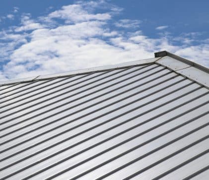Metal sheet roof and slope with clouds and blue sky background - Big Easy Roof Team